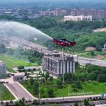 Drone pompier chinois à hélices carénées projetant de l’eau sur un immeuble en hauteur lors d’un exercice de lutte contre un incendie